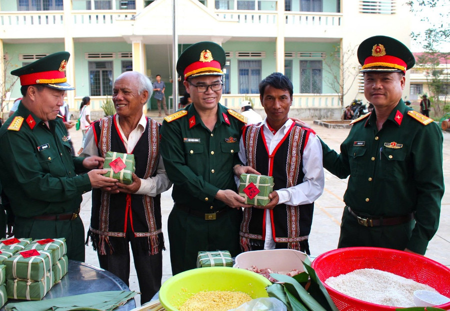 Lãnh đạo Binh đoàn 15 và lãnh đạo Đoàn Kinh tế - Quốc phòng 74 tặng bánh chưng cho người dân. Ảnh: V.H