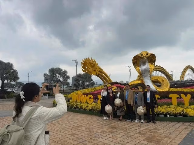 Du khách check-in tại điểm trang trí linh vật chính dịp Tết Ất Tỵ 2025. ẢNH: NGUYỄN TÚ