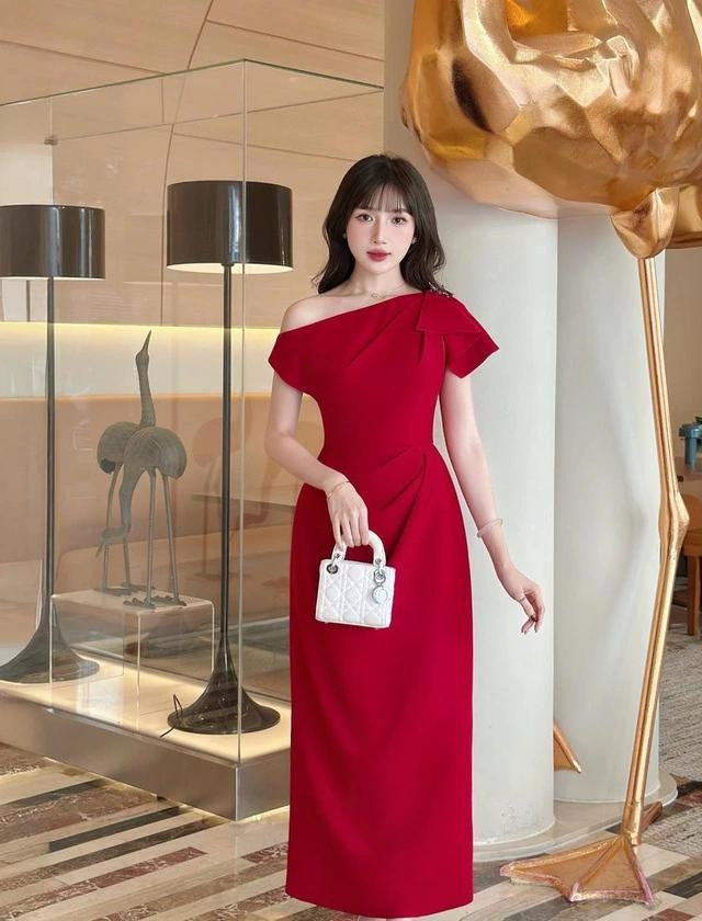 Khoác lên sắc đỏ nồng nàn, mẫu váy tựa như ánh lửa bừng sáng giữa không khí rộn ràng mùa lễ hội, tôn lên vẻ đẹp vừa kiêu sa vừa đằm thắm. Với thiết kế trễ vai tinh tế cùng chất liệu được chế tác tỉ mỉ, chiếc váy khéo léo làm nổi bật từng đường nét mềm mại. ẢNH: LAVIEM
