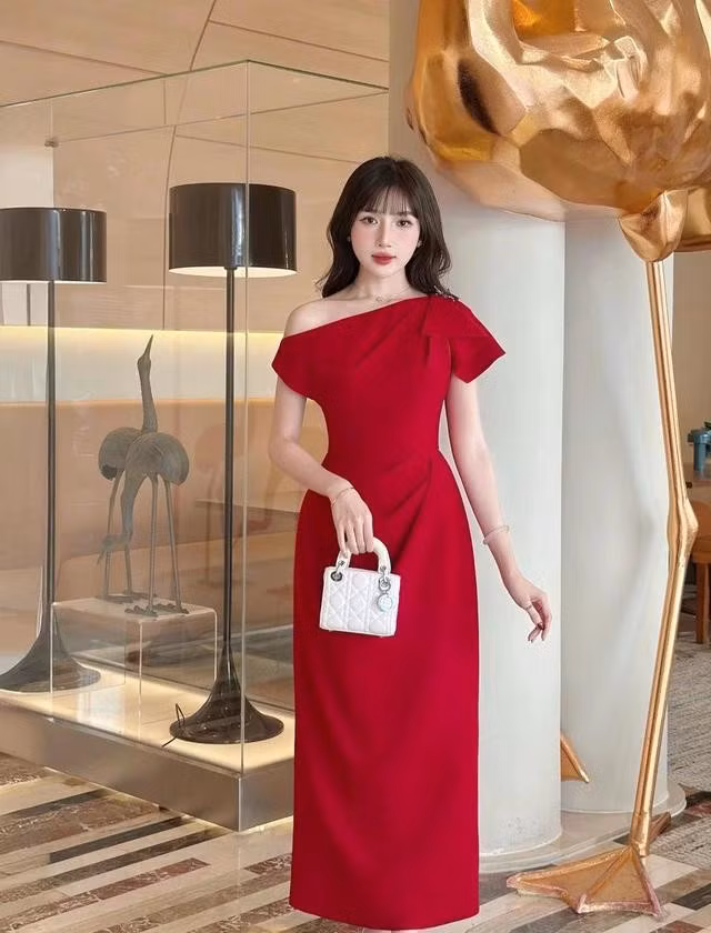 Khoác lên sắc đỏ nồng nàn, mẫu váy tựa như ánh lửa bừng sáng giữa không khí rộn ràng mùa lễ hội, tôn lên vẻ đẹp vừa kiêu sa vừa đằm thắm. Với thiết kế trễ vai tinh tế cùng chất liệu được chế tác tỉ mỉ, chiếc váy khéo léo làm nổi bật từng đường nét mềm mại. ẢNH: LAVIEM