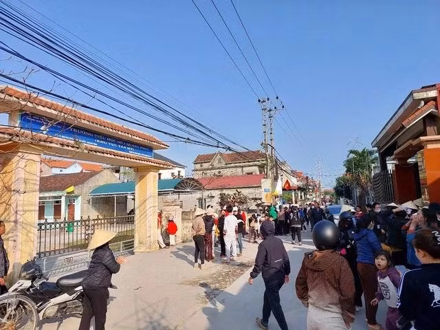 Phụ huynh, học sinh đứng ngoài cổng điểm trường Tân Mỹ.. Ảnh: Thanh Lộc