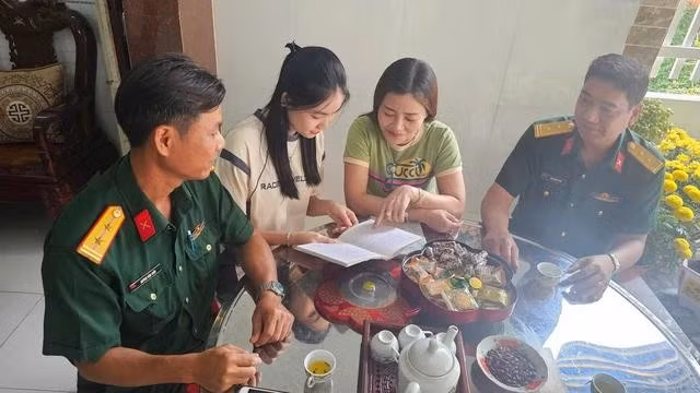Cha mẹ Trúc khoe những nét chữ đẹp của con gái cho đại diện Ban Chỉ huy quân sự TP.Trà Vinh (bìa phải) trước ngày giao quân