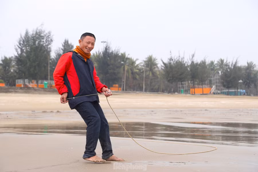 Lưới đã thả xong, ông Nam hô to: “Kéo thôi anh em ơi..!”. Nghe hiệu lệnh, 10 người đang đứng trên bờ lập tức chia thành hai nhóm, hợp sức kéo tấm lưới, đi giật lùi vào bờ. “Tôi đã gắn bó với lưới rùng hơn 30 năm nay. Hết thời ngược xuôi trên biển thì về bám lưới cho đỡ nhớ nghề thôi. Nghề này, vất vả, hao sức nhưng ít rủi ro hơn. Chúng tôi trở lại công việc từ ngày mùng 4 Tết. Mấy hôm nay trời lạnh, công việc vất vả hơn”, ông Nam thổ lộ.