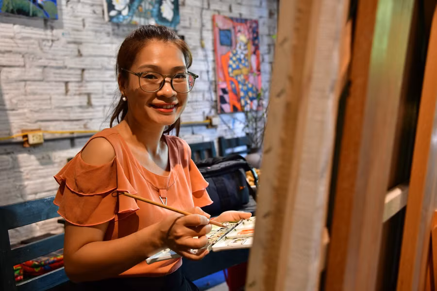 Họa sĩ Vũ Thùy Mai bên giá vẽ. ẢNH: LAM PHONG