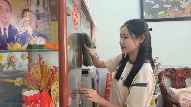 Nữ tân binh Huỳnh Mai Thanh Trúc giúp đỡ cha mẹ trước ngày lên đường nhập ngũ. ẢNH: NAM LONG