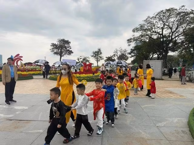 Trẻ em các trường tham quan điểm trang trí hoa xuân cầu Rồng. ẢNH: NGUYỄN TÚ