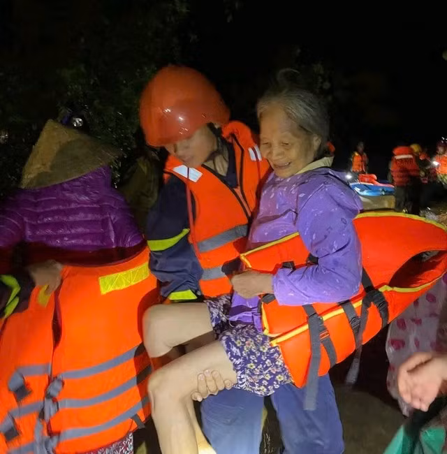 Lực lượng cứu hộ đưa người dân xã Vĩnh Long đến nơi an toàn. Ảnh: CACC