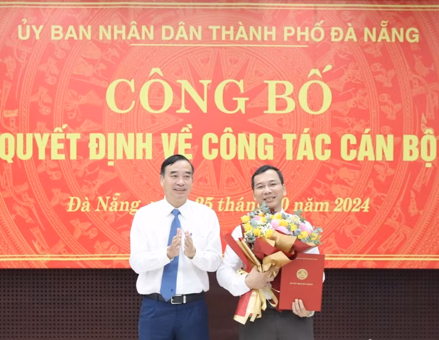 Chủ tịch UBND thành phố Lê Trung Chinh (trái) trao quyết định, tặng hoa chúc mừng tân Giám đốc Sở Nội vụ kiêm Chủ tịch UBND huyện Hoàng Sa, ông Nguyễn Hữu Lợi. (Ảnh: Báo Đà Nẵng)