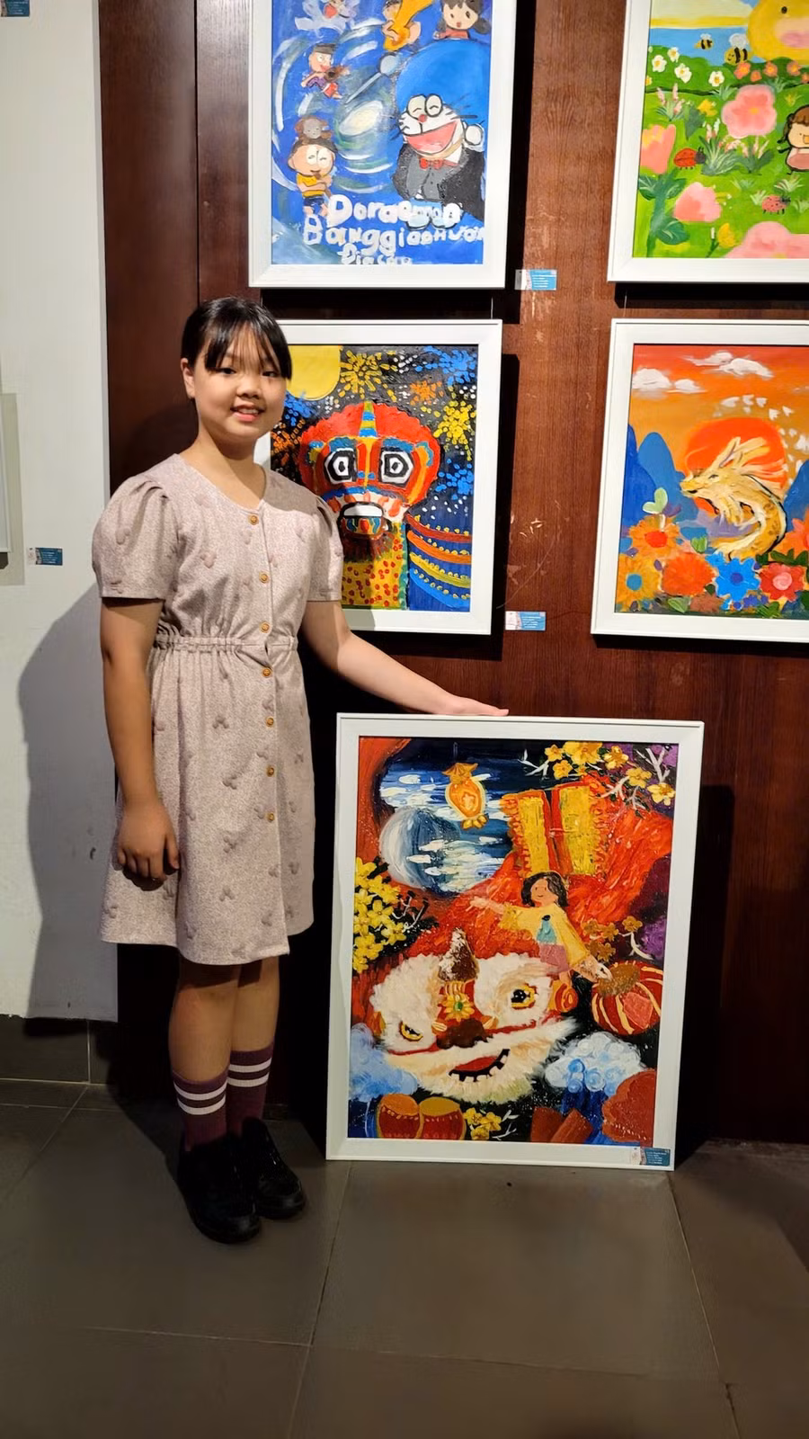 Bùi Vân Khánh bên cạnh tác phẩm của mình (tranh khổ lớn). (Ảnh: Minh Anh/Vietnam+)