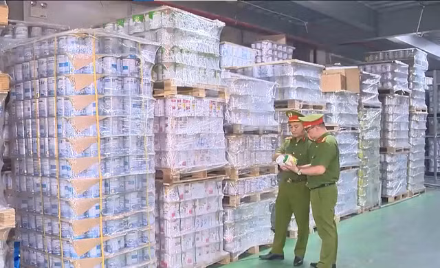 Lực lượng chức năng kiểm tra kho hàng trong đường dây sản xuất 573 loại sữa bột giả. Ảnh: VTV