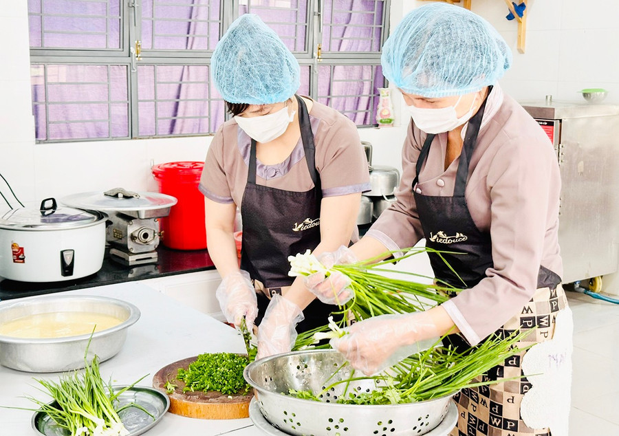 Các nhân viên cấp dưỡng Trường Tiểu học Nguyễn Thị Minh Khai (phường Hội Phú, TP. Pleiku) tuân thủ các quy định trong chế biến thực phẩm. Ảnh: N.N bep-an-tap-the-dd.jpg