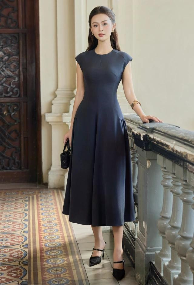 Gam màu xanh đen nền nã và mang tính ôn hòa, giúp quý cô hòa nhập vào không gian náo nhiệt một cách thoải mái và tự tin. Đầm dài luôn phù hợp với giày cao gót, các mẫu túi nhỏ cầm tay và trang sức/phụ kiện ánh kim, ánh bạc... ẢNH: MAYBI
