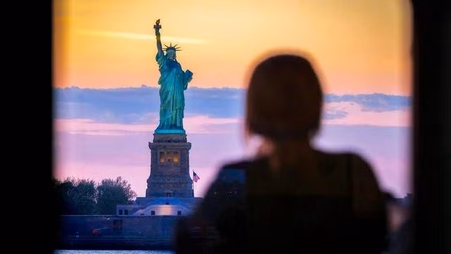 Du khách ngắm nhìn tượng Nữ thần Tự do từ một chuyến phà. ẢNH: GETTY