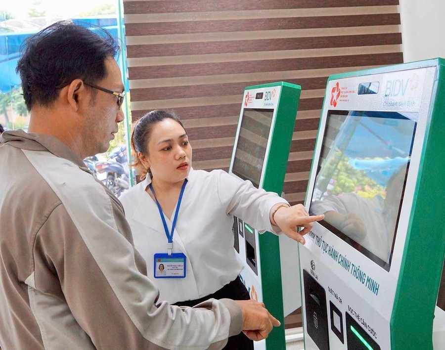 Hỗ trợ người dân thực hiện các bước tại KIOS TTHC thông minh tại Trung tâm Phục vụ hành chính công tỉnh. Ảnh: An Khang