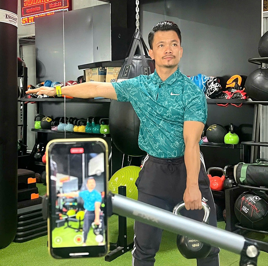 Anh Trần Việt Khải ghi hình nội dung hướng dẫn tập luyện thể chất tại một phòng gym ở TP. Pleiku. Ảnh: Ngọc Duy 2a.jpg