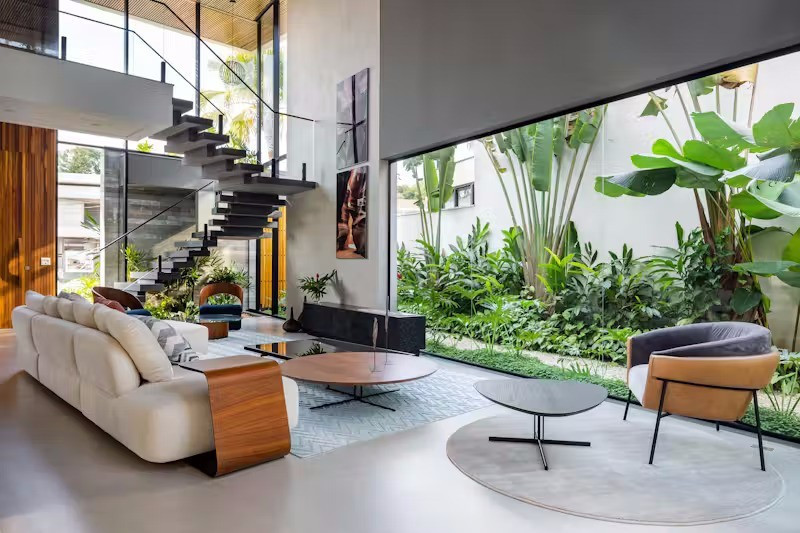 Nhờ các khung mở được bố trí chiến lược trong không gian sinh hoạt chung, ngôi nhà kết nối linh hoạt với không gian xanh quanh, đồng thời khai thác tối đa vẻ đẹp của kết cấu tự nhiên từ cảnh quan sân vườn đến thảm thực vật nhiệt đới của Đại Tây Dương bao quanh.