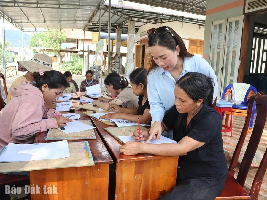 Các nghệ nhân và người dân địa phương học đường nét trang trí hoa văn sản phẩm gốm của người M'nông. 2gom.jpg