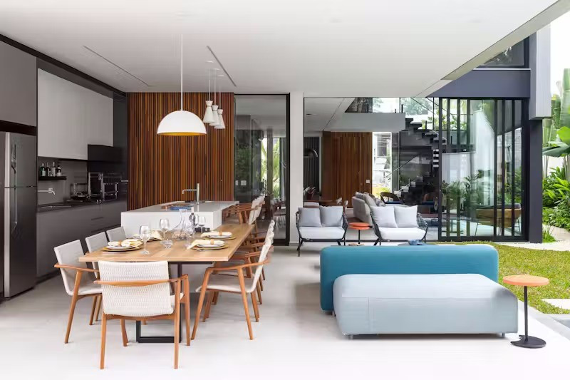 Bản thiết kế nhà hình chữ L cho phép không gian sinh hoạt chung mở rộng liền mạch ra hiên ngoài trời, nơi có khu vực bếp nướng và hồ bơi.