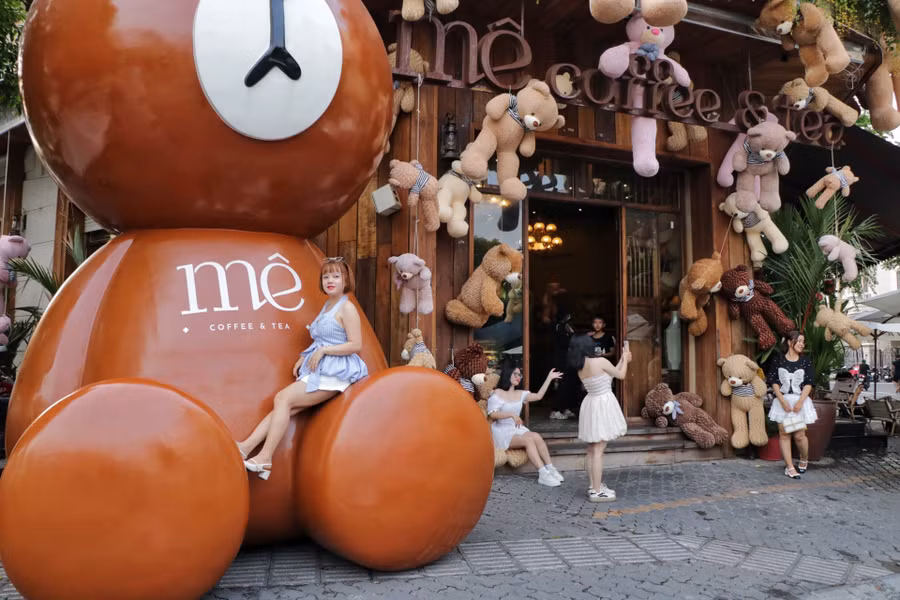 Nhiều khách thích thú chụp với chú gấu khổng lồ trước quán. ẢNH: CAO AN BIÊN