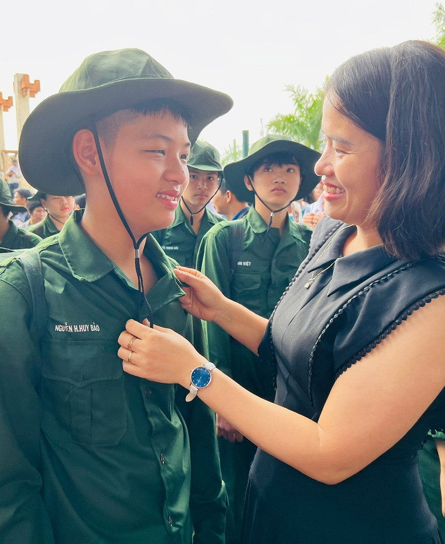Phụ huynh động viên em Nguyễn Huy Bảo trước khi lên đường tham gia huấn luyện tại Tiểu đoàn Bộ binh 50. Ảnh: Phan Lài 2c.jpg