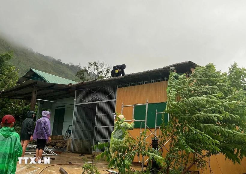 Lực lượng chức năng tỉnh Kon Tum hỗ trợ người dân khắc phục thiệt hại về nhà ở. Ảnh: TTXVN phát ktdd.jpg