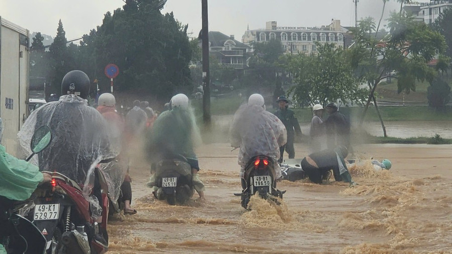 Nước chảy xiết làm người đi xe máy bị ngã ra đường tại khu vực hồ Xuân Hương, TP Đà Lạt