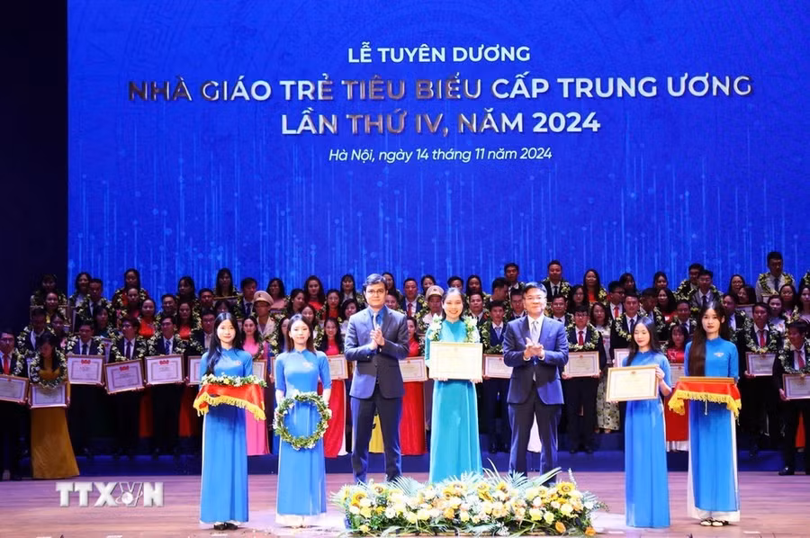 Phó Thủ tướng Lê Thành Long (phải) và Bí thư thứ nhất Ban Chấp hành Trung ương Đoàn Bùi Quang Huy trao giải thưởng "Nhà giáo trẻ tiêu biểu cấp Trung ương" lần thứ IV cho các thầy, cô giáo. (Ảnh: Minh Đức/TTXVN )