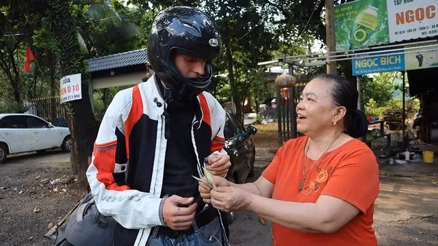 Bà Kim không chỉ giúp băng bó, còn tặng Niko tiền khi biết thanh niên này đang khó khăn. ẢNH: Hoàng Giáp