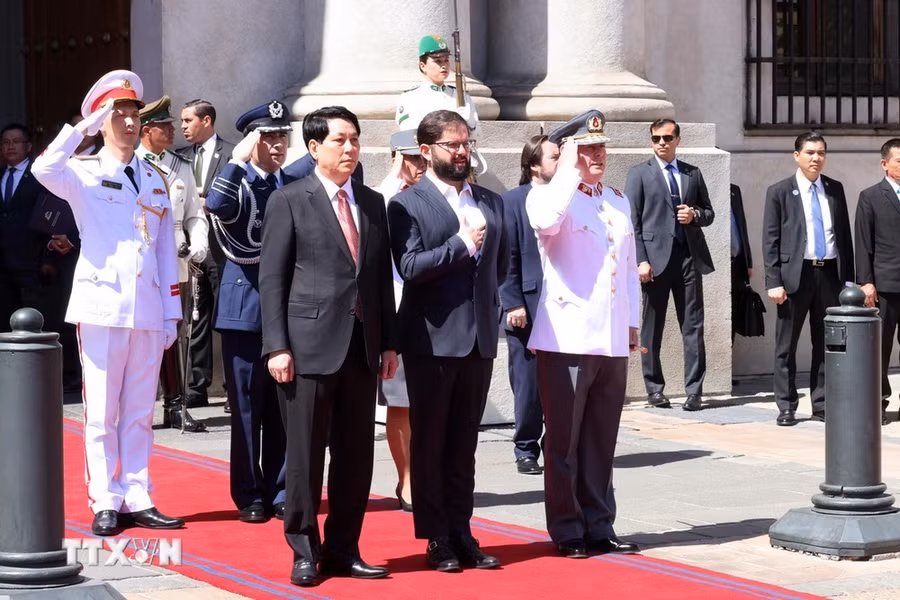 Chủ tịch nước Lương Cường và Tổng thống Chile Gabriel Boric thực hiện nghi lễ chào cờ. (Ảnh: Lâm Khánh/TTXVN)