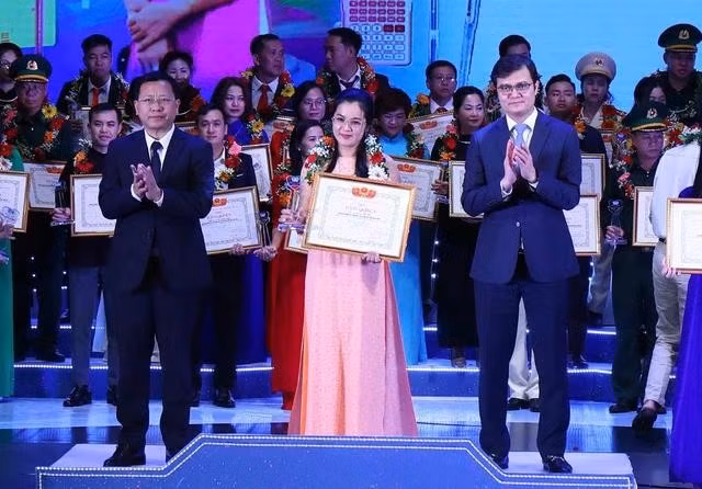 Anh Bùi Quang Huy và ông Trần Văn Đạt, Vụ trưởng Vụ Giáo dục chính trị và công tác học sinh, sinh viên (Bộ GD-ĐT) trao bằng khen cho giáo viên được tuyên dương. ẢNH: BẢO ANH