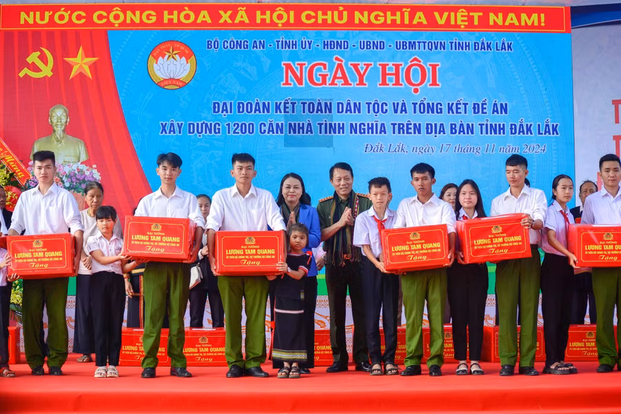 Bộ trưởng Bộ Công an Lương Tam Quang trao quà cho học sinh tại Ngày hội Đại đoàn kết toàn dân tộc ở tỉnh Đắk Lắk. ẢNH: HỮU TÚ