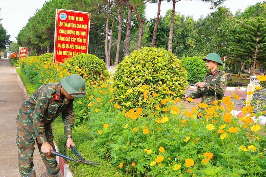 Bộ đội chăm sóc bồn hoa trong khuôn viên đơn vị. Ảnh: Thiên Di them4.jpg