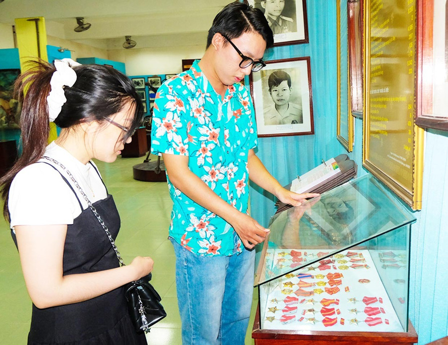 Anh Phạm Minh Huy (du khách đến từ TP Hồ Chí Minh) cùng bạn đang xem trưng bày huân chương, huy chương thời kháng chiến tại Bảo tàng tỉnh Gia Lai. Ảnh: Ngọc Nhuận them4.jpg