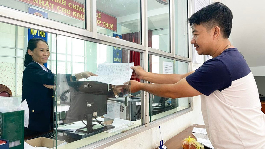 Công chức Thuế cơ sở 8 chủ động đảm nhiệm khâu trả kết quả hồ sơ trực tiếp đến người dân. Ảnh: Sơn Ca 1b.jpg