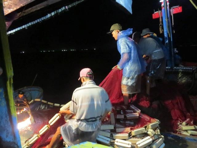 Bạn chài tàu cá ông Võ Xuân Cẩm kéo lưới trên biển đêm. ẢNH: TRANG THY