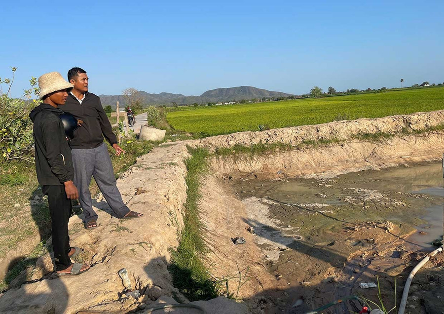 Để chủ động nguồn nước tưới cho cây trồng, anh Ksor La (bìa trái, buôn Ngôl) phải đào hồ chứa nước ngay giữa ruộng nhưng hiện hồ cũng đang cạn khô. Ảnh: V.C
