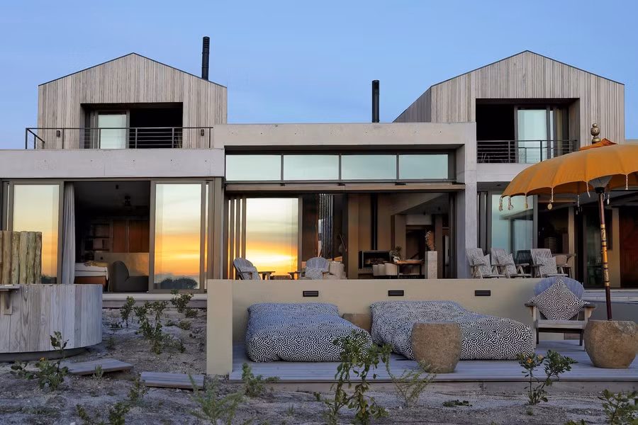 Nhóm kiến trúc lấy cảm hứng từ hình thái phân tách tự nhiên của thảm thực vật bản địa, chuyển hoá thành tổ hợp không gian đa lớp, vừa riêng biệt nhưng vẫn liên kết chặt chẽ. Kết quả tạo ra một quần thể kiến trúc dạng gian nhà tách biệt, cho phép cây cỏ bản địa len lỏi vào từng khu vực, phá vỡ ranh giới truyền thống giữa công trình và cảnh quan.