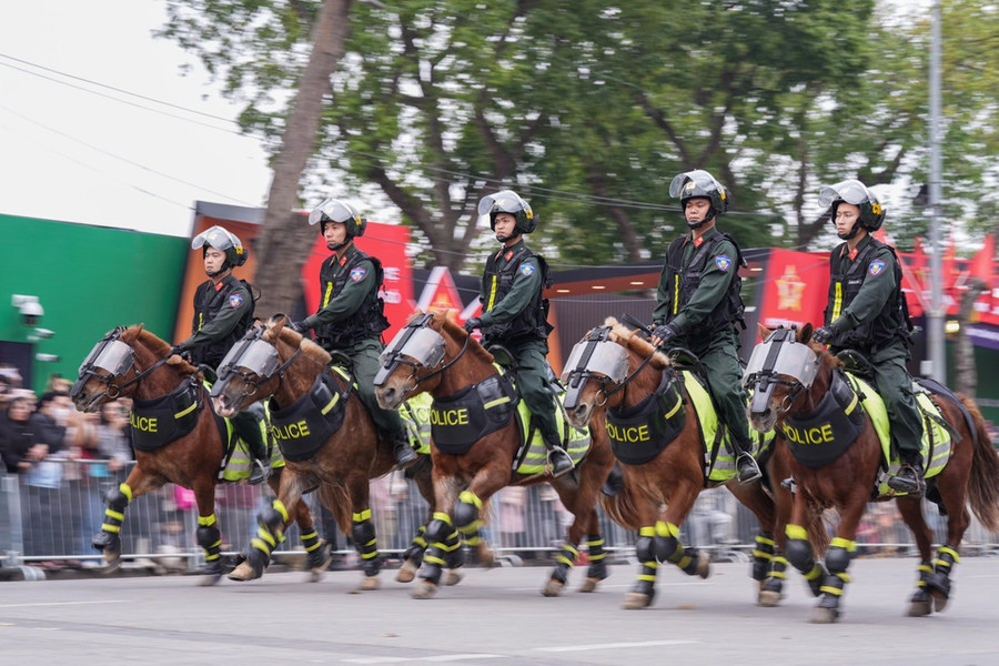 Các chiến sĩ cảnh sát cơ động điều khiển ngựa phi nước đại hàng ngang
