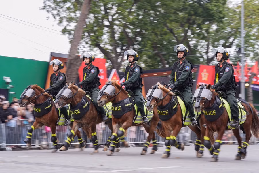 Các chiến sĩ cảnh sát cơ động điều khiển ngựa phi nước đại hàng ngang
