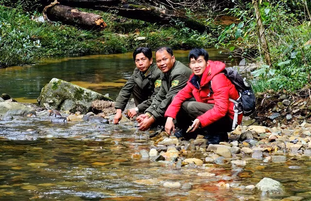 Anh Phạm Đờ Ni (góc trái) và anh Păng Tiang Min cùng cán bộ kiểm lâm rửa mặt bên con suối.