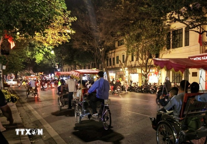Du khách ngắm phố phường Hà Nội trên những chuyến xích lô. (Ảnh: Tuấn Anh/TTXVN)