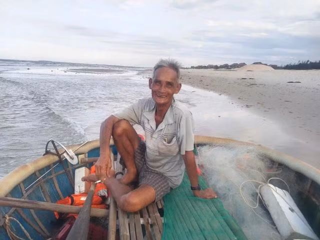 Ông Nguyễn Hùng chuẩn bị bơi chiếc thúng tròn ra biển đánh cá. ẢNH: QUANG VIÊN