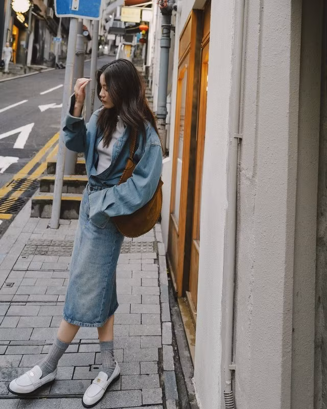 Dù là mùa lạnh cũng đừng quên item chân váy denim yêu thích của bạn. Chúng vẫn cực kỳ hợp mốt và dễ dàng tạo nên được bản phối phù hợp vào mùa này từ gợi ý của tín đồ thời trang- loafer màu trắng, tất xám, áo khoác và chân váy denim đồng điệu cùng điểm nhấn là túi da lộn màu nâu camel. ẢNH: JENNY TSANG