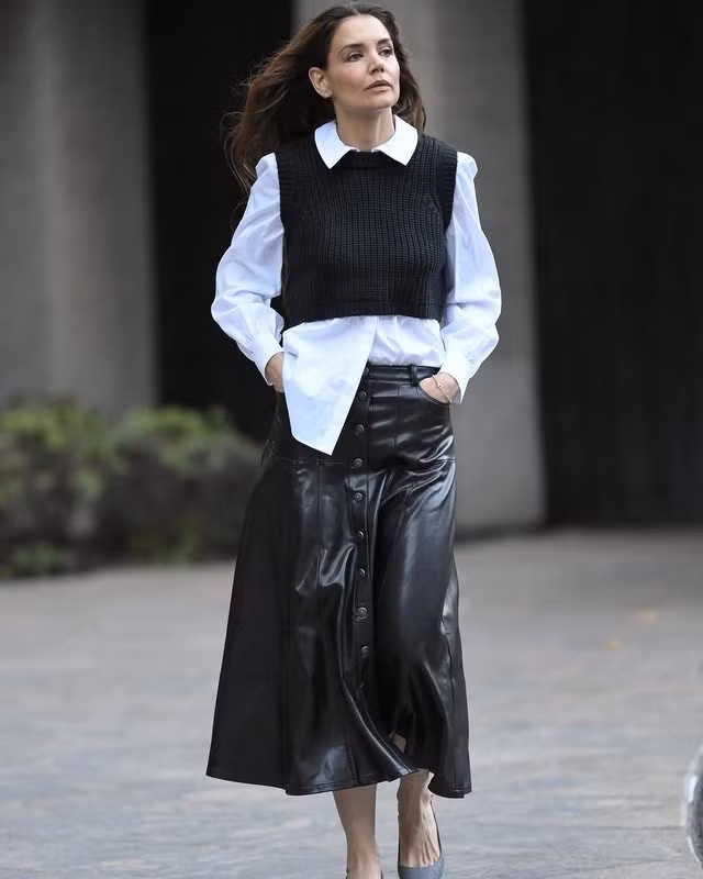 Nếu chân váy dáng ôm như chân váy bút chì, chân váy đuôi cá chất vải da quá thời trang và khó ứng dụng trong thực tế thì chân váy chữ A sẽ là giải pháp thay thế. Katie Homes ra phố với bản phối cực kỳ ấm áp và dễ dịu bao gồm áo gile len, sơ mi trắng và kiểu chân váy trendy điểm hàng cúc ấn tượng. ẢNH: INSTYLE