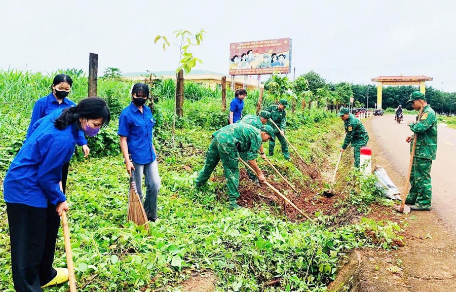 Cán bộ, chiến sĩ Đồn Biên phòng Ia Pnôn cùng đoàn viên thanh niên xã Ia Pnôn tham gia dọn vệ sinh đường làng. Ảnh: P.D bg5-1.jpg