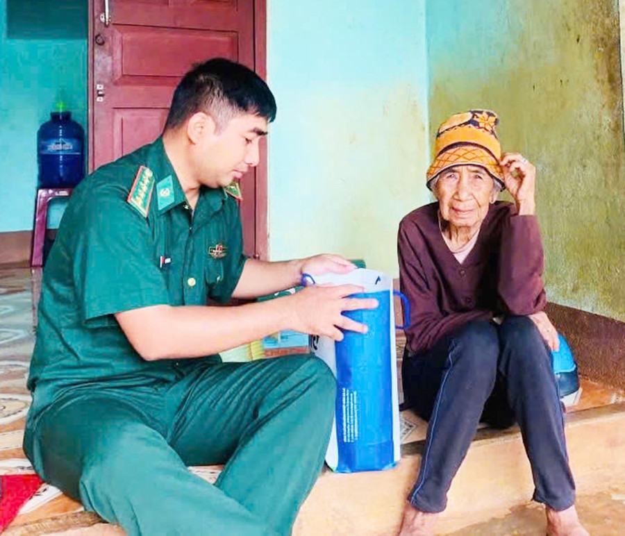Đại úy Rơ Châm Tuyn trò chuyện, thăm hỏi bà Rơ Lan H’Glăp. Ảnh: P.D bg5-2.jpg