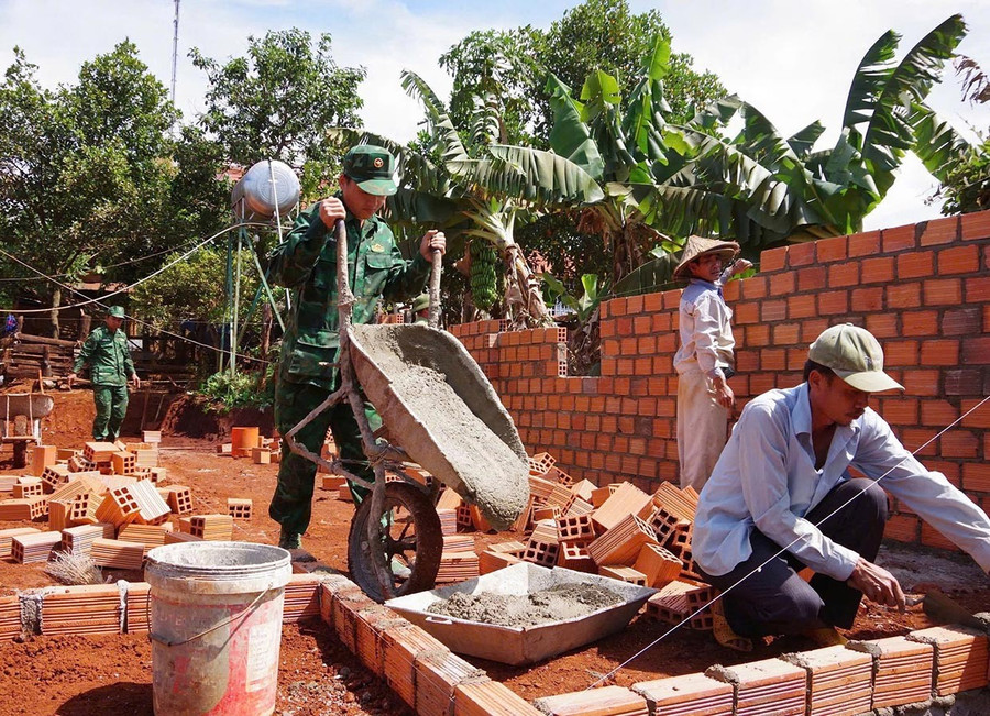 Cán bộ, chiến sĩ Đồn Biên phòng Ia Pnôn tham gia ngày công để xóa nhà tạm, nhà dột nát cho hộ dân trên địa bàn đóng quân. Ảnh: P.D them2-4829.jpg