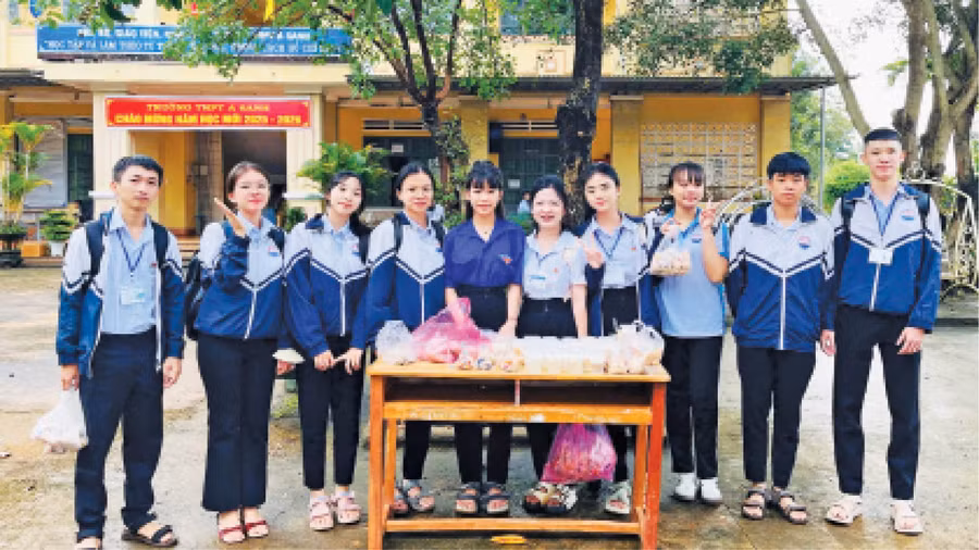 Em Trần Thị Nguyễn Hà (thứ 6 từ trái sang) cùng các bạn bán đồ ăn để gây quỹ tổ chức hoạt động thiện nguyện. Ảnh: NVCC