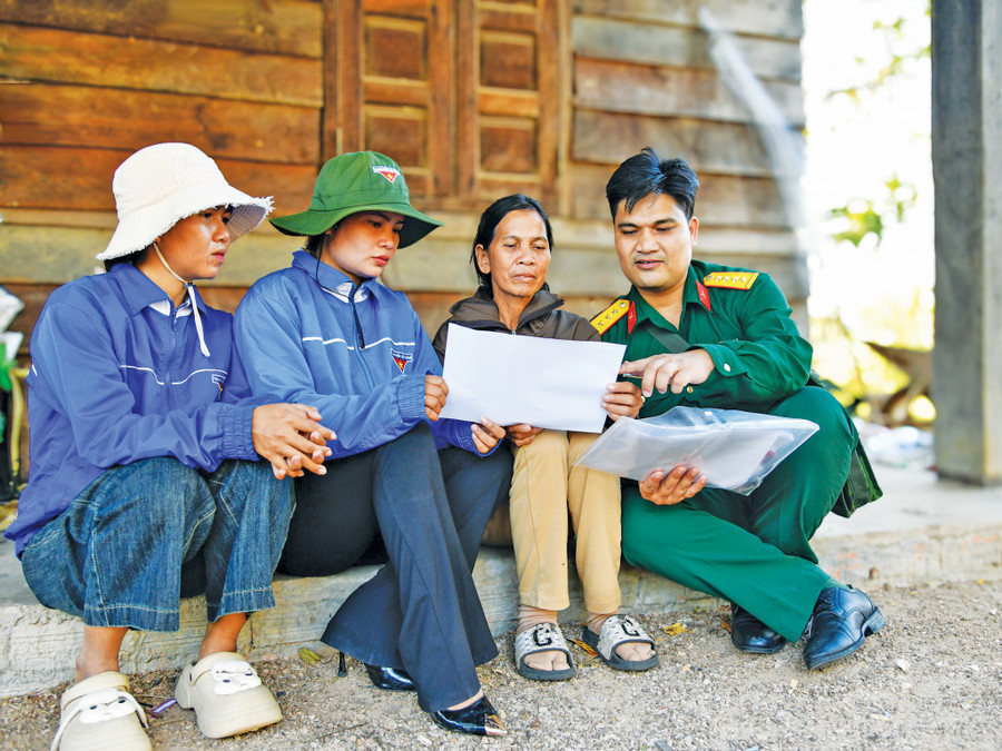 Đại úy Đinh Trung Khiếu (bìa phải) tham gia tuyên truyền pháp luật cho người dân. Ảnh: H.P
