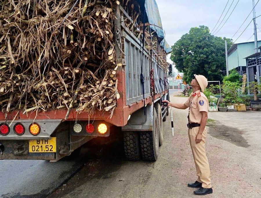 Cán bộ Đội Cảnh sát giao thông đường bộ số 1 kiểm tra chiều cao phương tiện kinh doanh vận tải tại tuyến đường Trường Sơn Đông đoạn qua xã Ia Pa. Ảnh: ĐVCC